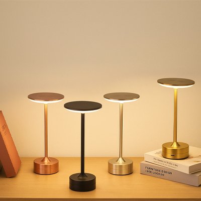 Ensemble de lampes LED sans fil aux finitions noir, or rose, argent et doré, exposées sur une étagère moderne.