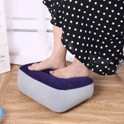 Femme posant ses pieds sur un repose-pieds de bureau confortable pour détendre ses jambes pendant le travail.
