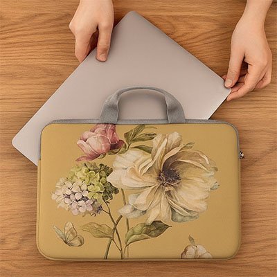 Femme insérant son ordinateur portable dans une sacoche protectrice à fleurs.