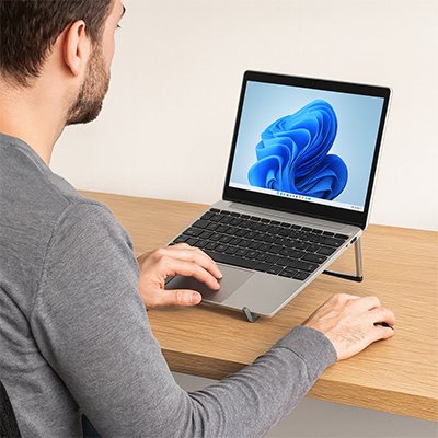 Utilisateur travaillant avec un ordinateur sur un support portable réglable