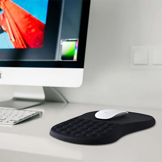 Tapis de souris ergonomique noir alvéolé en gel utilisé avec un iMac, idéal pour le confort, la précision et la prévention des tensions du poignet.