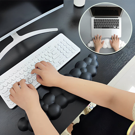 Mains sur un clavier avec un repose-poignet blanc en forme de nuage, vu de dessus.