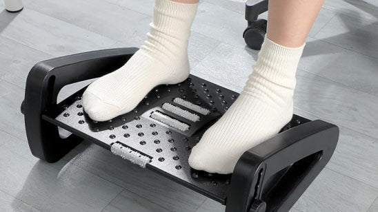 Pieds posés sur un repose-pieds de bureau ergonomique à surface texturée