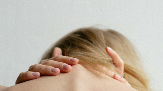 Personne se massant la nuque pour soulager des tensions cervicales liées au télétravail, masseur cervical