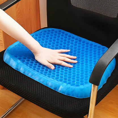 Main appuyant sur un coussin en gel bleu alvéolé, illustrant sa texture souple et sa capacité d’absorption de la pression.