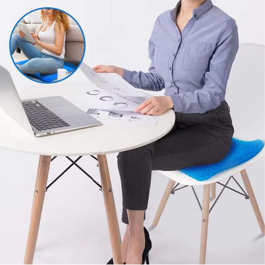 Femme travaillant à son bureau assise sur un coussin en gel bleu respirant, parfait pour le télétravail et les longues heures assises.