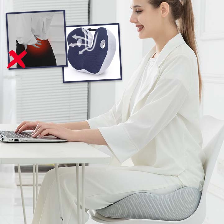 Femme travaillant sur ordinateur assise sur un coussin ergonomique de siège pour prévenir les douleurs lombaires.