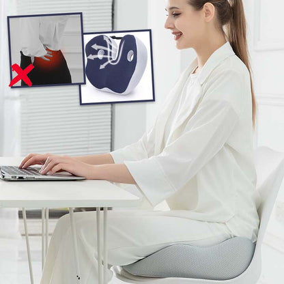 Femme travaillant sur ordinateur assise sur un coussin ergonomique de siège pour prévenir les douleurs lombaires.