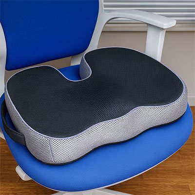 Coussin ergonomique noir et gris en forme de U placé sur une chaise bleue, conçu pour soulager le coccyx et améliorer le confort d’assise.