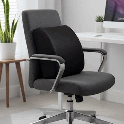 Coussin de soutien lombaire noir placé sur une chaise de bureau ergonomique, idéal pour améliorer la posture et prévenir les douleurs dorsales.