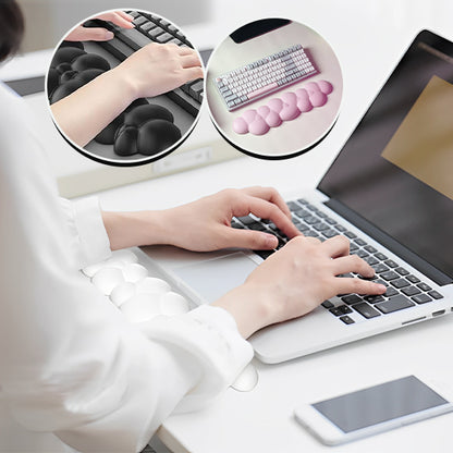 Personne tapant sur un clavier avec un repose-poignet noir en forme de nuage, et un insert circulaire montrant un modèle blanc sur ordinateur portable.

