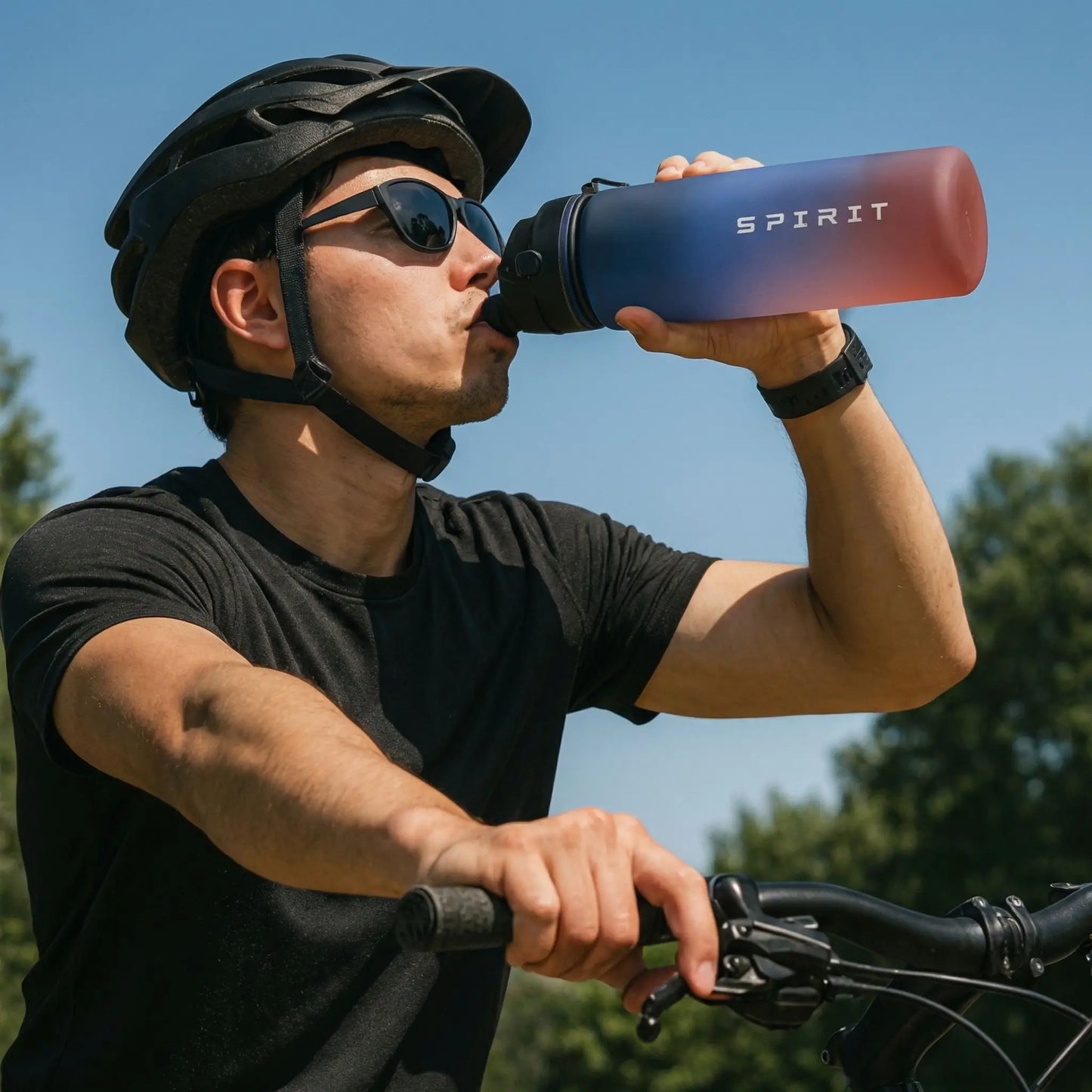 Homme a velo qui boit avec une gourde de sport sans BPA, pratique pour l’hydratation pendant l’effort