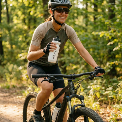 Femme sportive en pleine sortie nature buvant avec une gourde sport 600 ml WRELS blanche