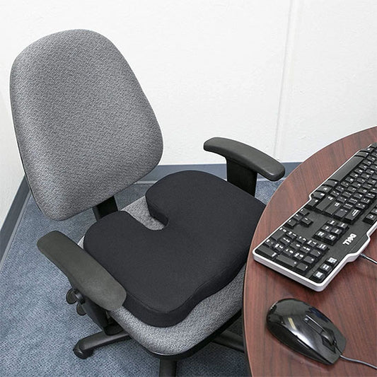 Coussin ergonomique en forme de U posé sur une chaise de bureau, vue rapprochée.