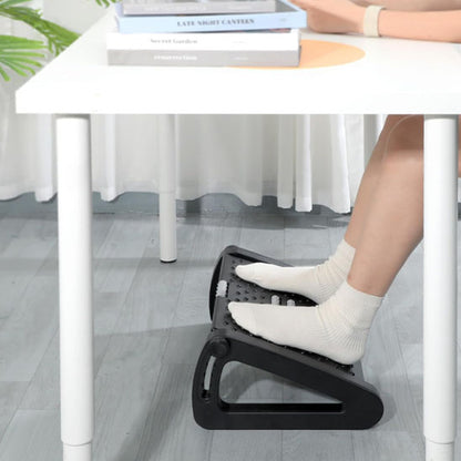 Personne détendue, pieds sur le repose-pied ergonomique placé dans un salon