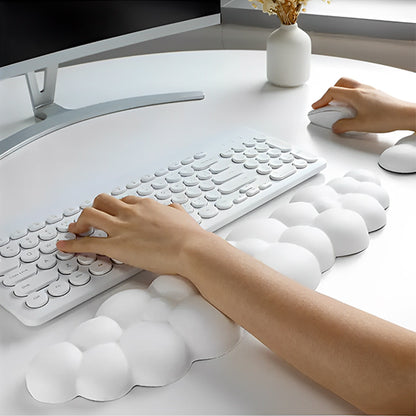 Personne utilisant un clavier avec un repose-poignet blanc en forme de nuage, apportant confort et soutien ergonomique.
