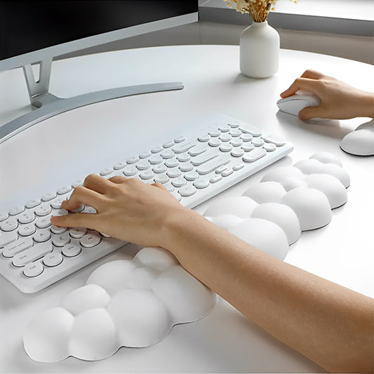 Personne utilisant un clavier avec un repose-poignet blanc en forme de nuage, apportant confort et soutien ergonomique.