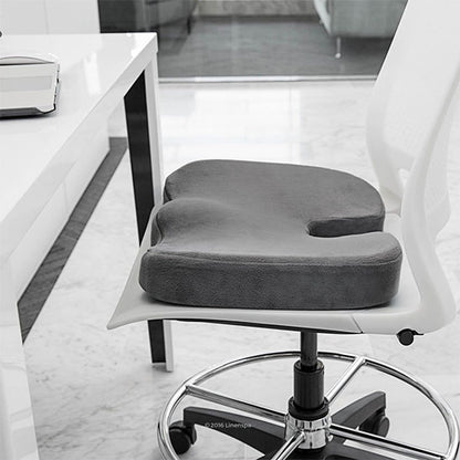 Coussin gris sur chaise design, indiqué pour soulager les douleurs de dos.