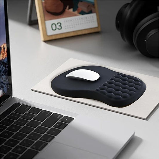 Tapis de souris ergonomique noir avec repose-poignet en gel alvéolé placé sur un bureau avec ordinateur portable, idéal pour réduire les douleurs liées au canal carpien.