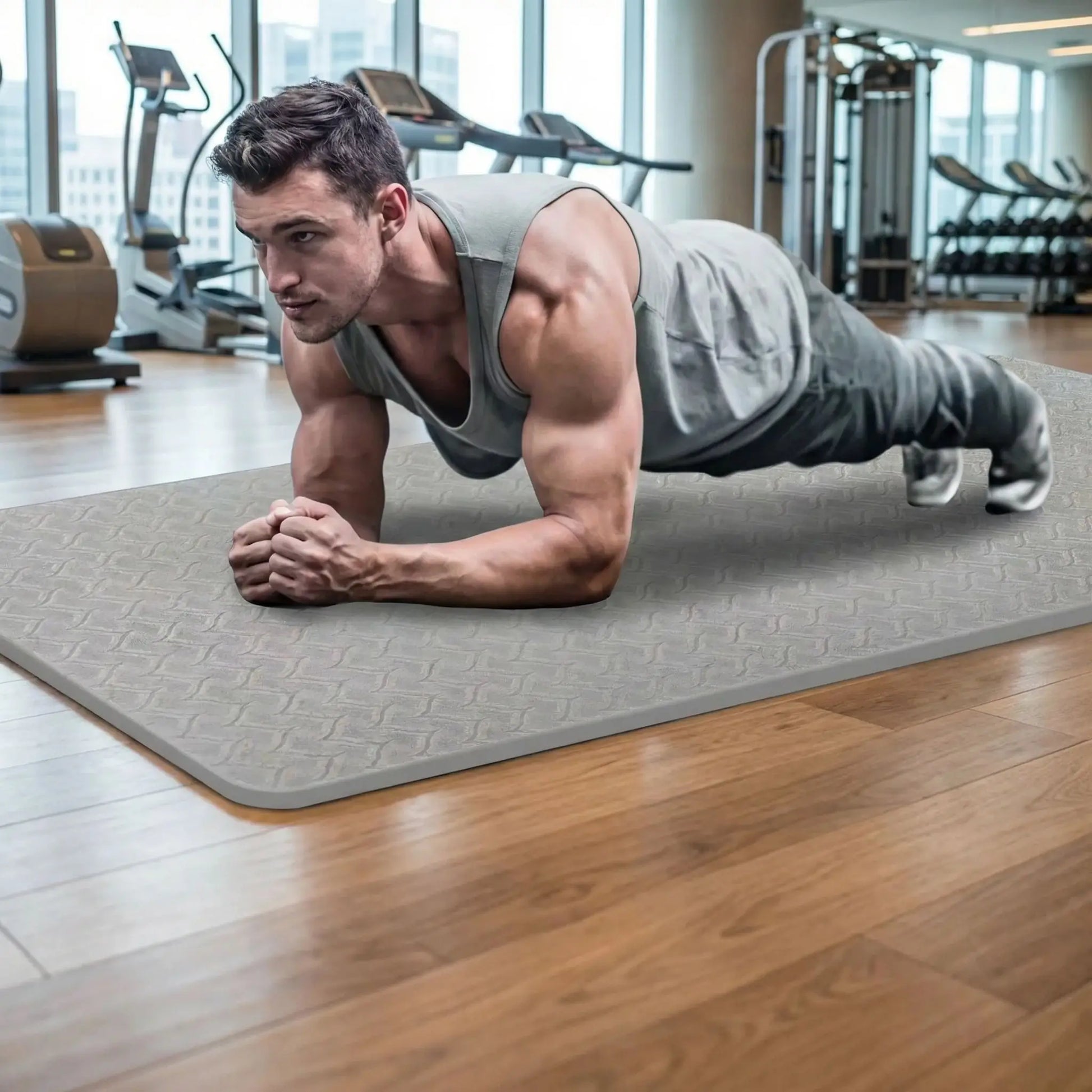 Homme réalisant un exercice de gainage sur tapis de yoga antidérapant 6 mm gris dans une salle de sport moderne