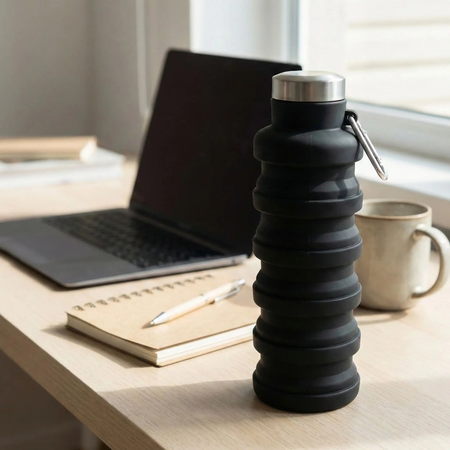 gourde de sport rétractable posée sur un bureau de télétravail avec ordinateur portable