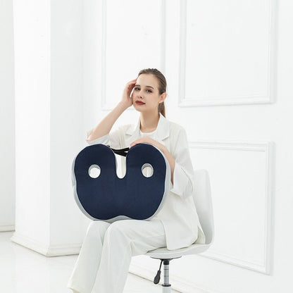 Femme assise sur une chaise tenant un coussin ergonomique de siège bleu pour montrer sa praticité et sa portabilité.